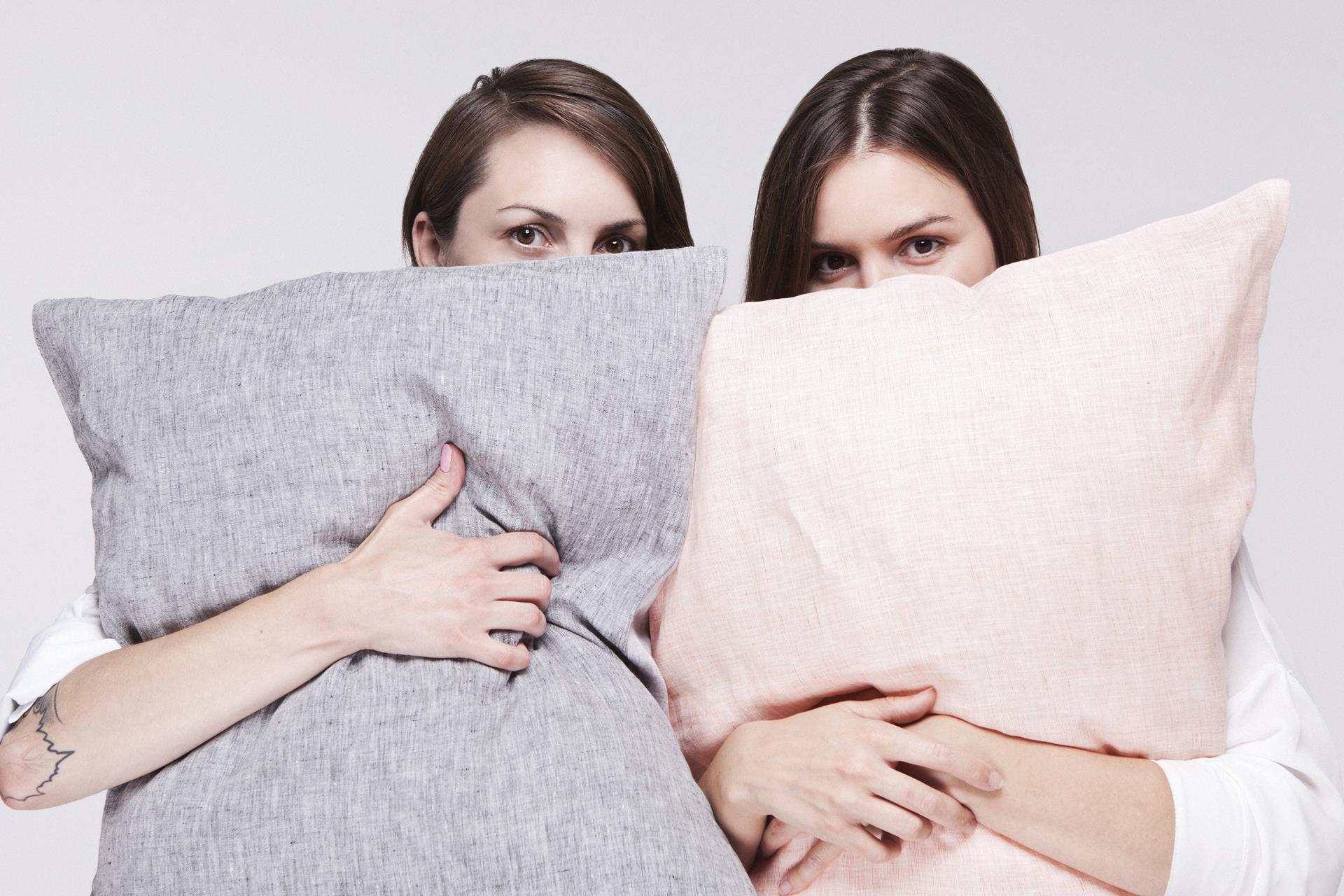 dwie młode kobiety z poduszkami